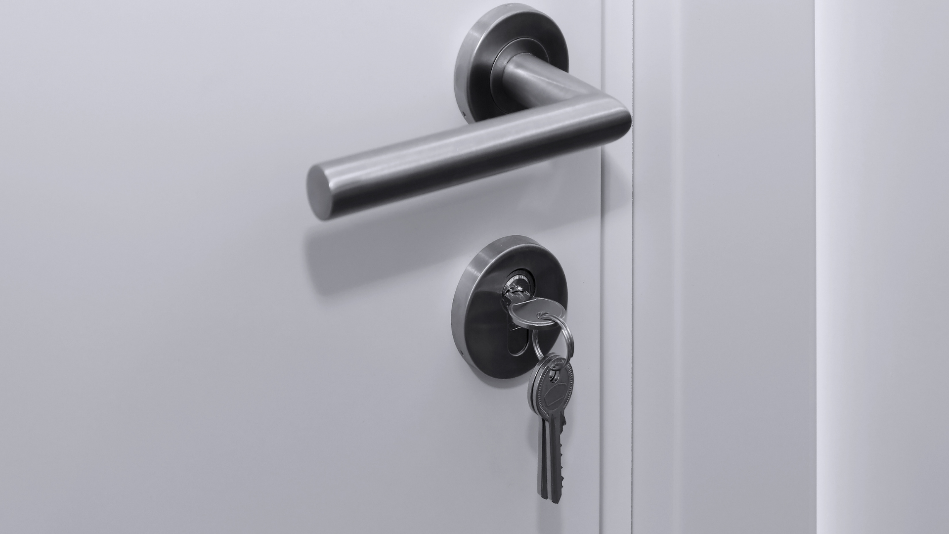 Keys left in the euro cylinder of a white front door after an emergency lockout