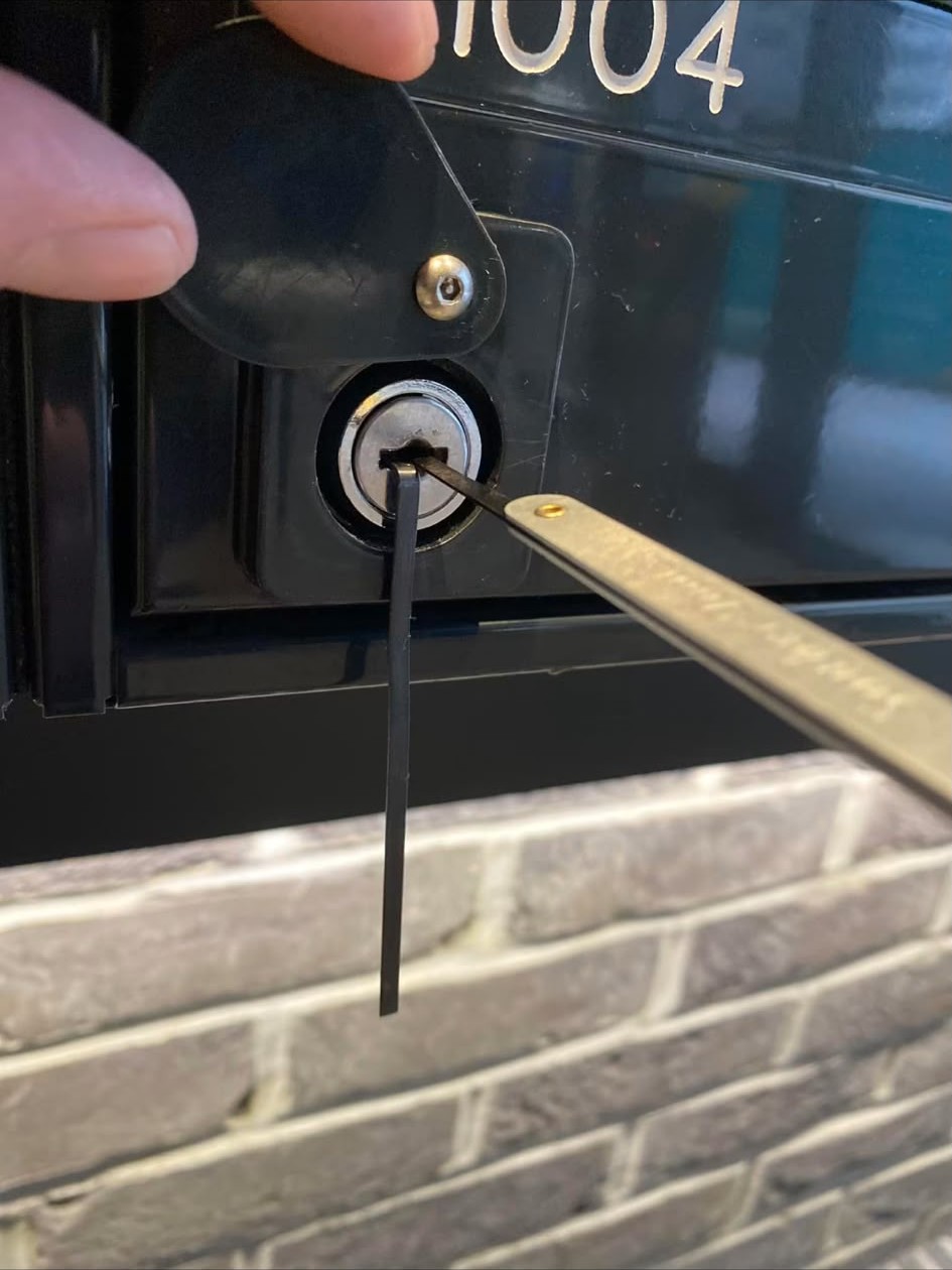 Locksmith picking a metal lockbox during non-destructive gaining entry work in London