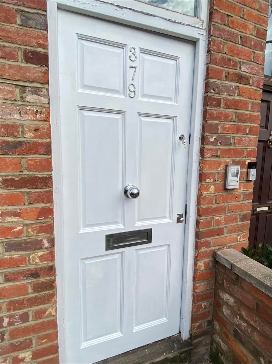 Repaired white front door with new anti-snap lock fitted after a London burglary repair